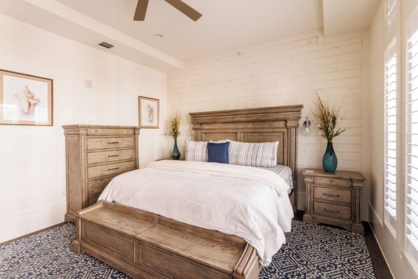 Traditional bedroom with a large bed, nightstands, and patterned floor.