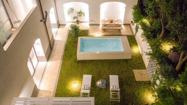 A rooftop pool area with a rectangular pool, lounge chairs, and a dining table set for four. - Luxury Villa with Penthouse, Pools and Sea View (Sant'Agnello)