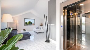 A modern living room with a sofa, a coffee table, and a lamp. There is a white wall with a picture frame and a window. - Luxury Villa with Penthouse, Pools and Sea View (Sant'Agnello)
