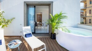 A balcony with a white lounge chair, a small table with magazines, a potted plant, and a hot tub. - Luxury Villa with Penthouse, Pools and Sea View (Sant'Agnello)