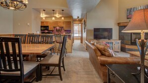 A spacious living area with a dining table, chairs, a sofa, and a television. - Spacious 3-Bedroom + Loft Condo at Timber Run – Perfect for Families and Groups! (Steamboat Springs)