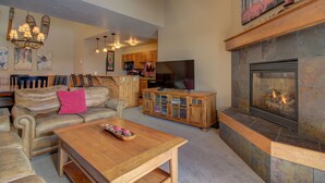 A spacious living room with a fireplace, leather sofas, a wooden coffee table, and a television. - Spacious 3-Bedroom + Loft Condo at Timber Run – Perfect for Families and Groups! (Steamboat Springs)