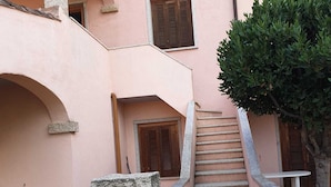 A narrow stone staircase leading to a door with a window above it. - A stone's throw from the center (San Teodoro)