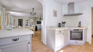 A modern kitchen with white cabinetry, a built-in oven, and a central island. - 4 BEDROOM VILLA - PRIVATE POOL AND GARDEN (N°348) (La Motte)