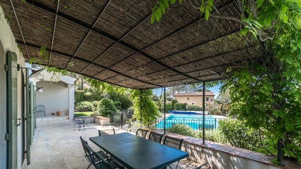 An outdoor patio with a table and chairs, a pool, and a covered area with a thatched roof. - 5 BEDROOM VILLA WITH PRIVATE POOL AND GARDEN (N°359) (La Motte)