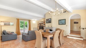 A spacious living area with a dining table, sofas, and a chandelier. - 3 BEDROOM VILLA WITH PRIVATE POOL AND GARDEN (N°355) (La Motte)