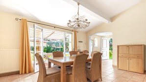 A dining area with a table, chairs, a chandelier, and a view through large windows. - 3 BEDROOM VILLA WITH PRIVATE POOL AND GARDEN (N°355) (La Motte)