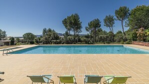A rectangular swimming pool with a tiled deck, surrounded by trees and a clear sky. - 3-BEDROOM TOWNHOUSE WITH GARDEN (N°501) (La Motte)