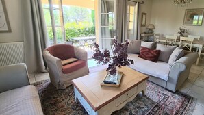 A living room with a sofa, armchair, coffee table, and a view of the outdoors. - 3 BEDROOM TOWNHOUSE WITH GARDEN (N°528) (La Motte)