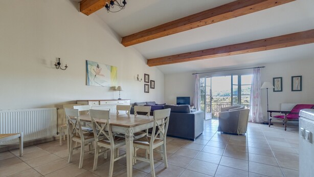 A spacious living area with a dining table and chairs, a sofa, and a television. - 3 BEDROOM TOWNHOUSE WITH GARDEN (N°565) (La Motte)
