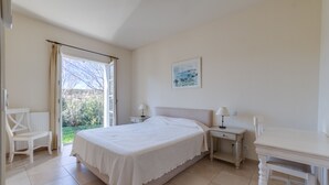 A bedroom with a bed, bedside tables, a chair, and a view of the outdoors. - 3 BEDROOM TOWNHOUSE WITH GARDEN (N°565) (La Motte)