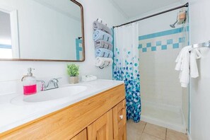 Bathtub, hair dryer, towels, shampoo