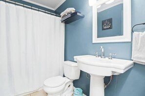 Een bad, een haardroger, handdoeken, shampoo