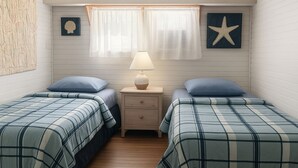 A bedroom with two beds, a nightstand, a lamp, and a window with curtains.