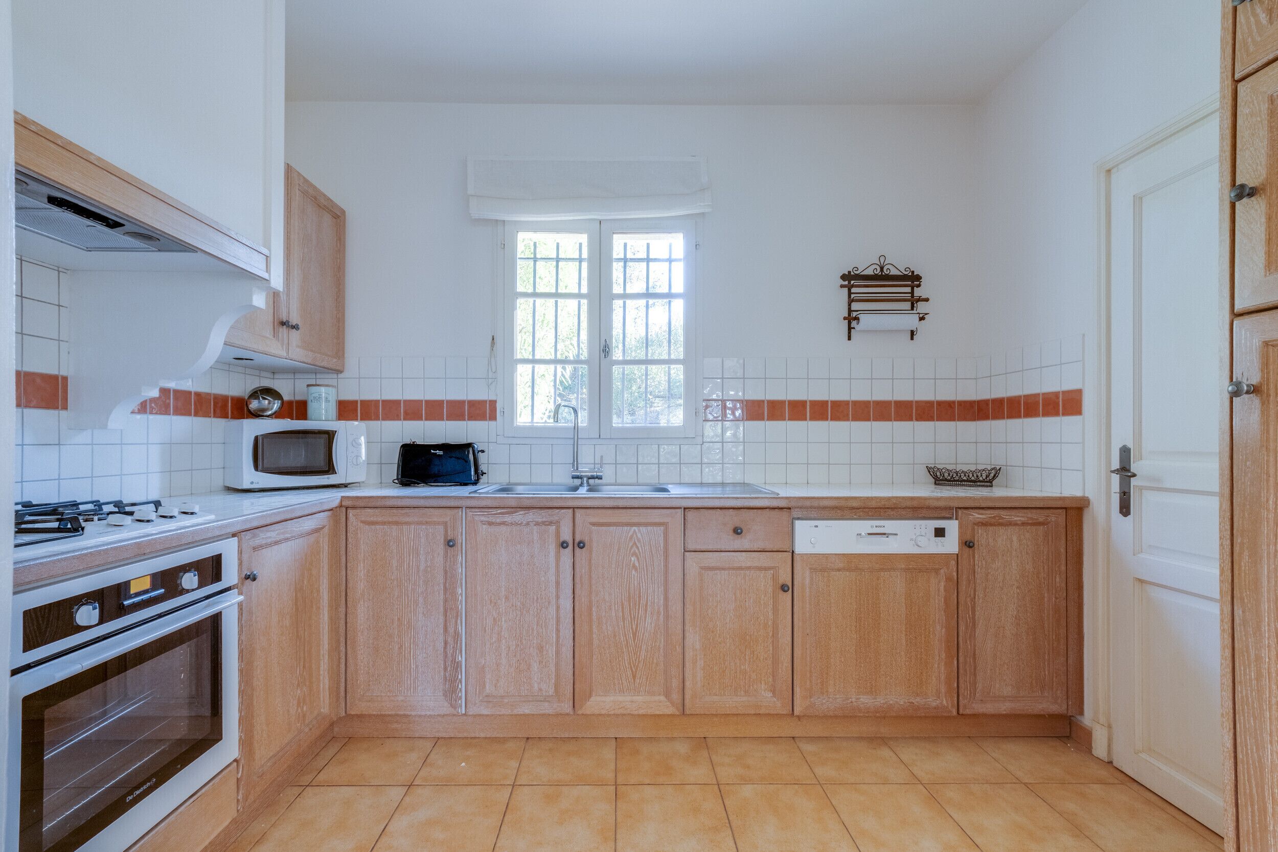 A kitchen with wooden cabinets, a microwave, a stove, and a dishwasher.