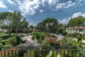 A residential area with a paved driveway, surrounded by trees and greenery. - 3-BEDROOM TOWNHOUSE WITH GARDEN (N°419) (La Motte)