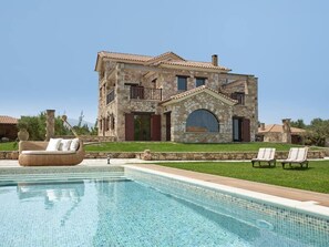 A stone building with a pool, lounge chairs, and a clear sky. - Palazzo Villa, World 5th Awarded Villa (Zakynthos)