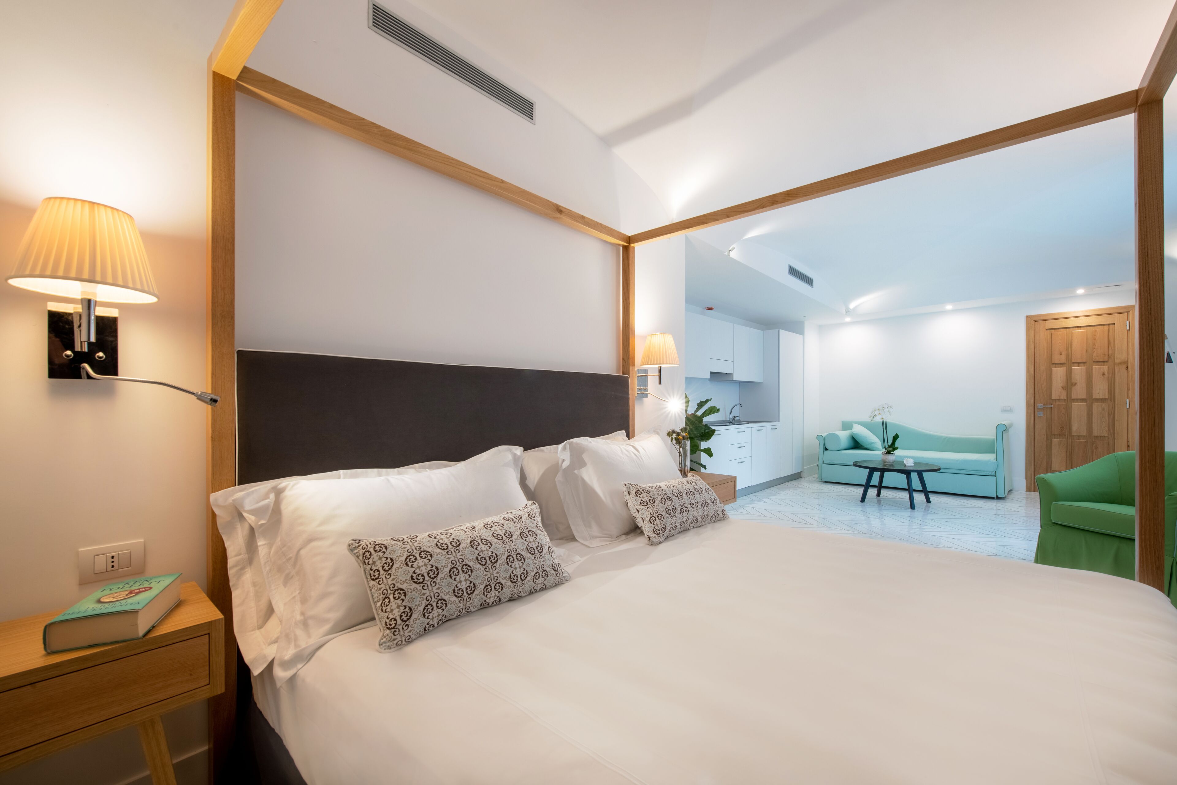 Un hotel moderno con una cama grande, lámparas de noche, una mesita de noche y vistas al área de estar.