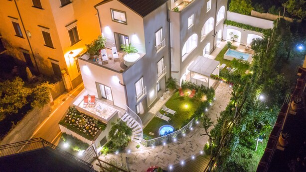 Un edificio a più piani con terrazza sul tetto, piscina e scala a chiocciola.