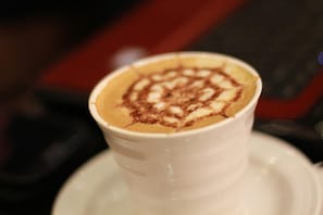 A cup of coffee with a latte art design on a saucer. - Rest Night Serviced Apartments - AL Nafal رست نايت للشقق المخدومة - النفل (Riyadh)