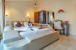 A modern hotel room with a large bed, a sofa, a desk, and a chair. - Shanti Solitaire Arpora (Arpora)