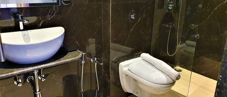 Een moderne badkamer met een wit wastafel, toilet en douche.