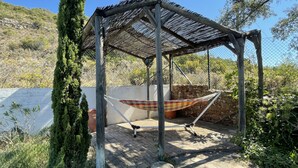 A covered outdoor seating area with a hammock.