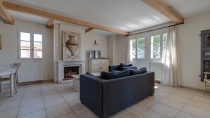 A living room with a fireplace, a sofa, a dining table, and a view of the outside. - 2 BEDROOM APARTMENT WITH TERRACE (N°513) (La Motte)