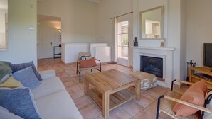A spacious living room with a fireplace, a sofa, a coffee table, and a television. - 2-BEDROOM TOWNHOUSE WITH GARDEN (N°330) (La Motte)