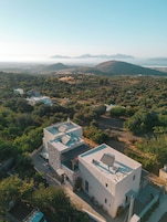 Una villa moderna con techo plano, fachada de piedra y patio amoblado.