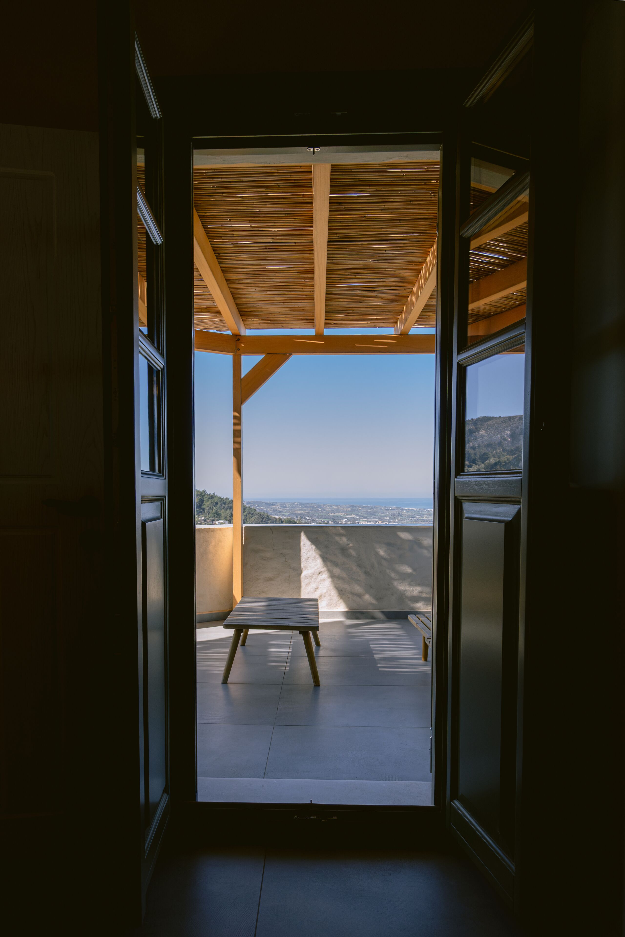 An interior space with a view of a balcony and a clear sky.