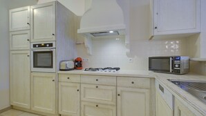 A kitchen with white cabinets, a stove, an oven, a microwave, and a toaster. - 2 BEDROOM TOWNHOUSE WITH GARDEN (N°507) (La Motte)