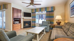 A living room with a fireplace, a television, and a ceiling fan. - Charming Lodge-Style Resort with Something to do in Every Season! (Zephyr Cove)