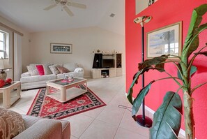 A living room with a sofa, coffee table, and a TV stand. - Endless Summer (Port Charlotte)
