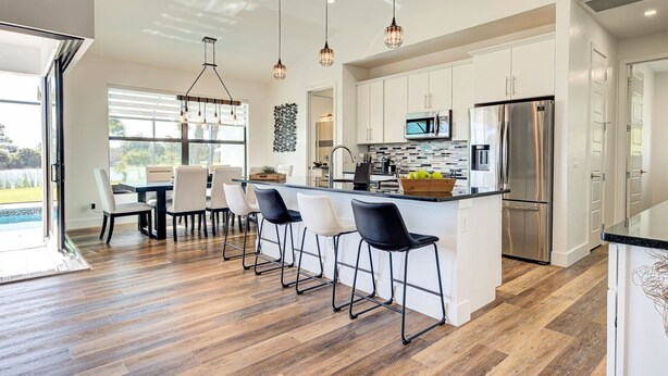 Una cocina moderna con una isla central, electrodomésticos de acero inoxidable y una zona de comedor con vistas.