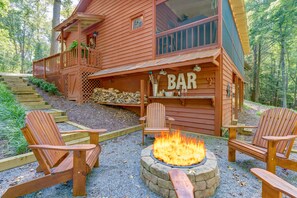 A rustic cabin with a fire pit and outdoor seating.