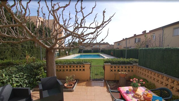 A patio area with a pool, outdoor furniture, and a table set for a meal. - Charming house for rent in Roses, Costa Brava! 1200 meters from the beach. Large terrace and community pool. (Roses)