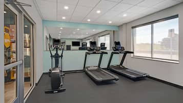 A gym with treadmills, a stationary bike, and a mirrored wall.
