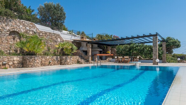 A swimming pool with stone walls and a pergola. - Villa Adamite (2 bedrooms) (Lavrio)