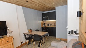 A compact living space with a dining area, kitchenette, and a sofa. - 5pers. Running boards Modern Mountain View (Valmeinier)