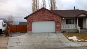 A single-story house with a garage, a front porch, and a visible address number. - Large, comfortable home in Pocatello (Pocatello)