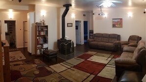 A living room with a fireplace, a sofa set, a bookshelf, and a rug. - Large, comfortable home in Pocatello (Pocatello)