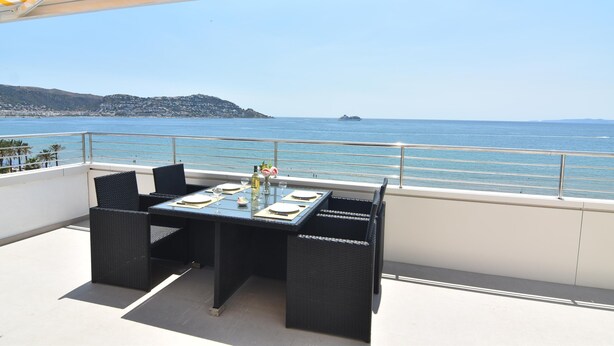 Una terraza con una mesa preparada para dos, con vistas al mar.