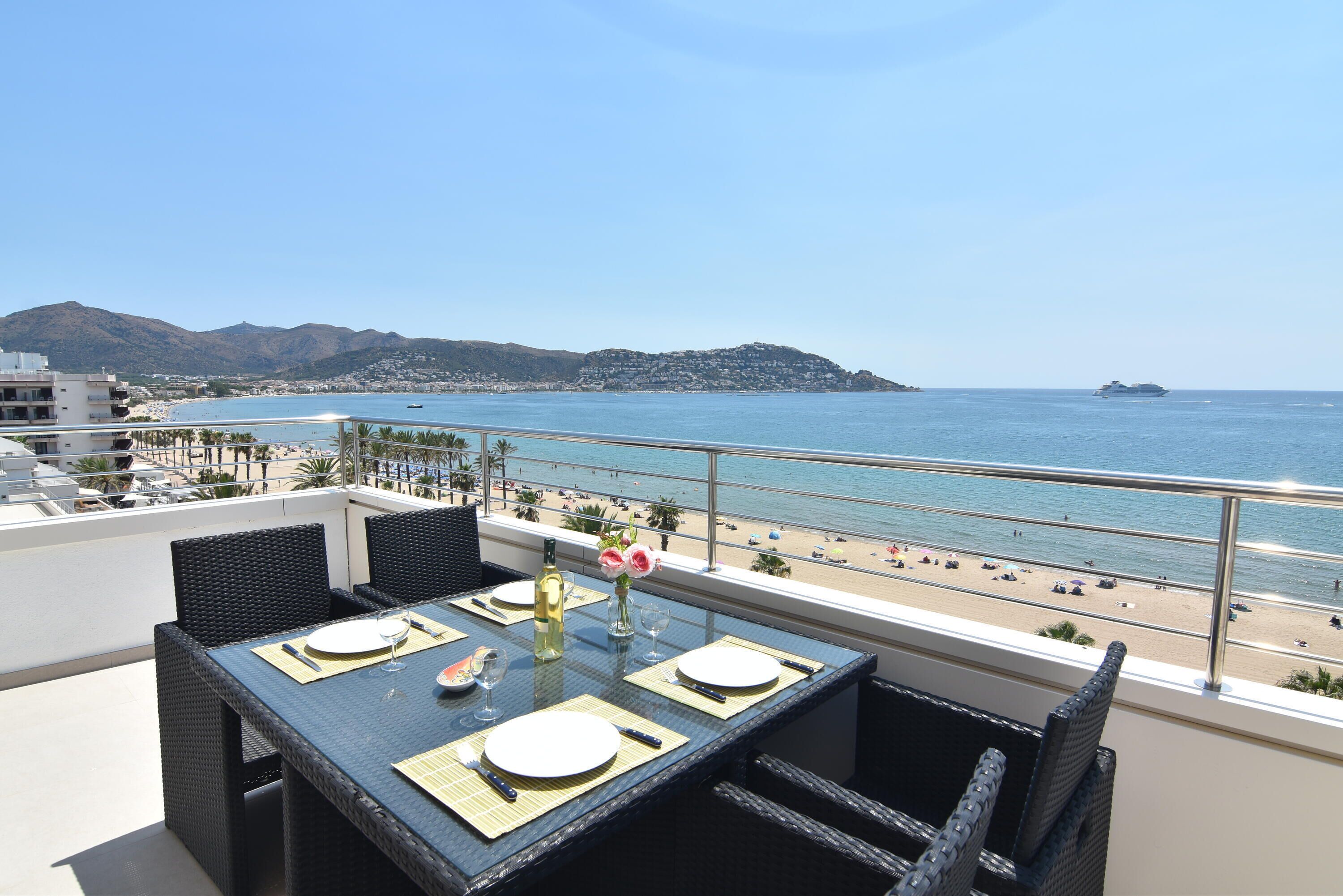 Ein Essbereich mit Tisch für zwei Personen mit Blick auf Strand und Meer.