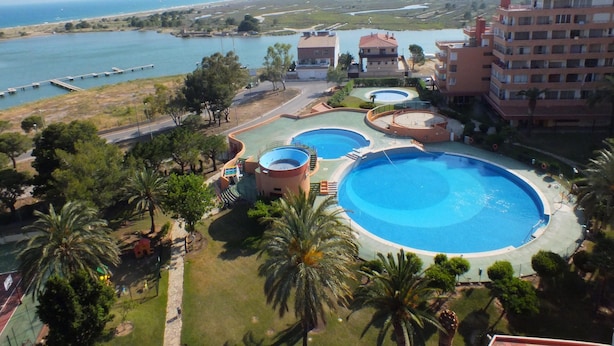 Ein Resort mit mehreren Schwimmbecken, einer Marina und Blick auf das Meer.