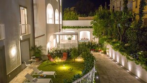 A courtyard with a small garden, seating area, and a pergola. - Luxury Apartment with Penthouse and Pool (Sant'Agnello)