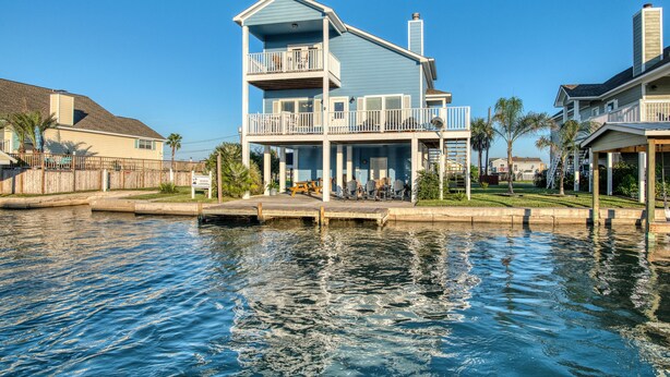 A two-story waterfront house with a balcony, a dock, and a small deck area. - Coastal Class Waterfront - "Your Home away from Home" (Rockport)