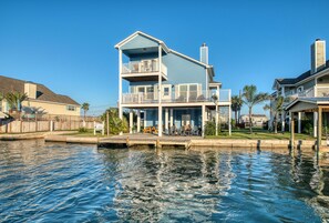 A two-story waterfront house with a balcony, a dock, and a small deck area. - Coastal Class Waterfront - "Your Home away from Home" (Rockport)
