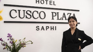 A reception desk with a sign that reads "Hotel Cusco Plaza" and the name "SAPHI" below it. - Cusco Plaza Saphi (Cusco)