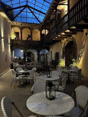 An indoor courtyard with multiple seating areas, a glass ceiling, and a staircase. - Cusco Plaza Saphi (Cusco)